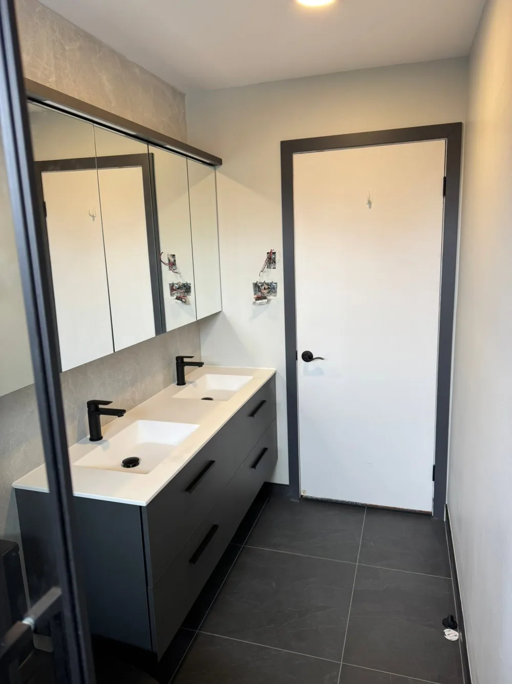 Détail d’une vanité double installée dans une salle de bain rénovée